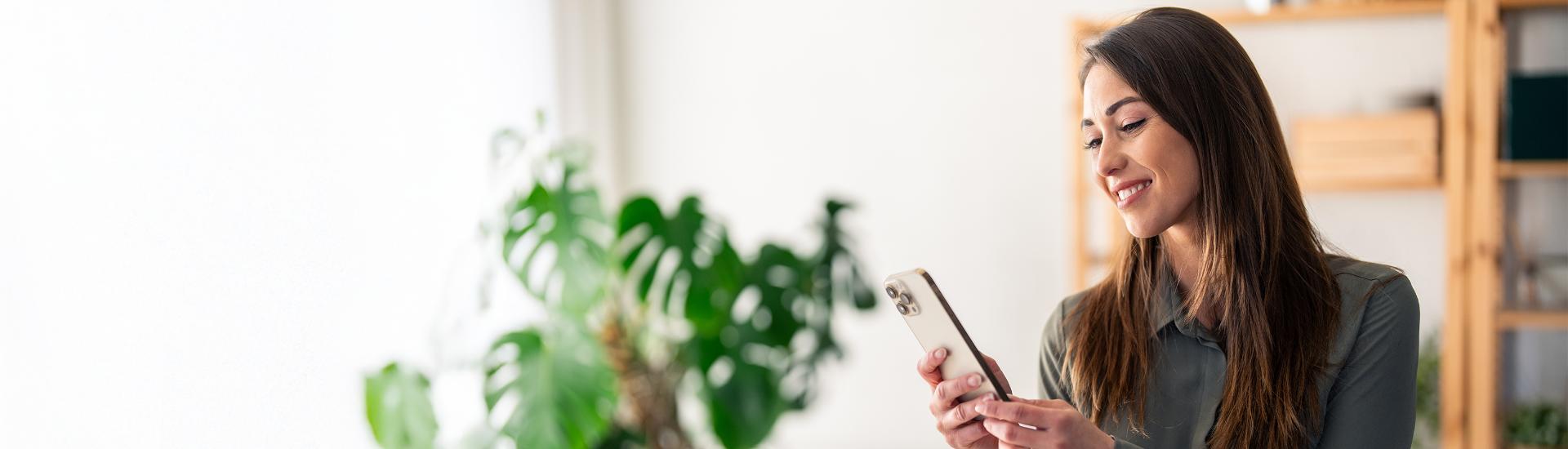 laechelnde frau mit handy in der hand