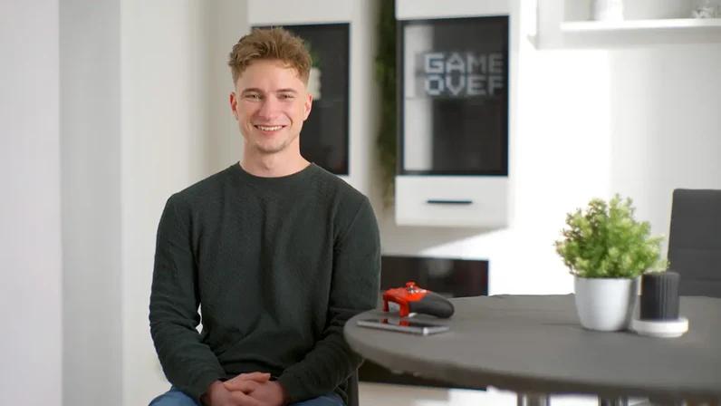 junger mann am tisch mit gamingcontroller | 1&1 junger mann am tisch mit gamingcontroller